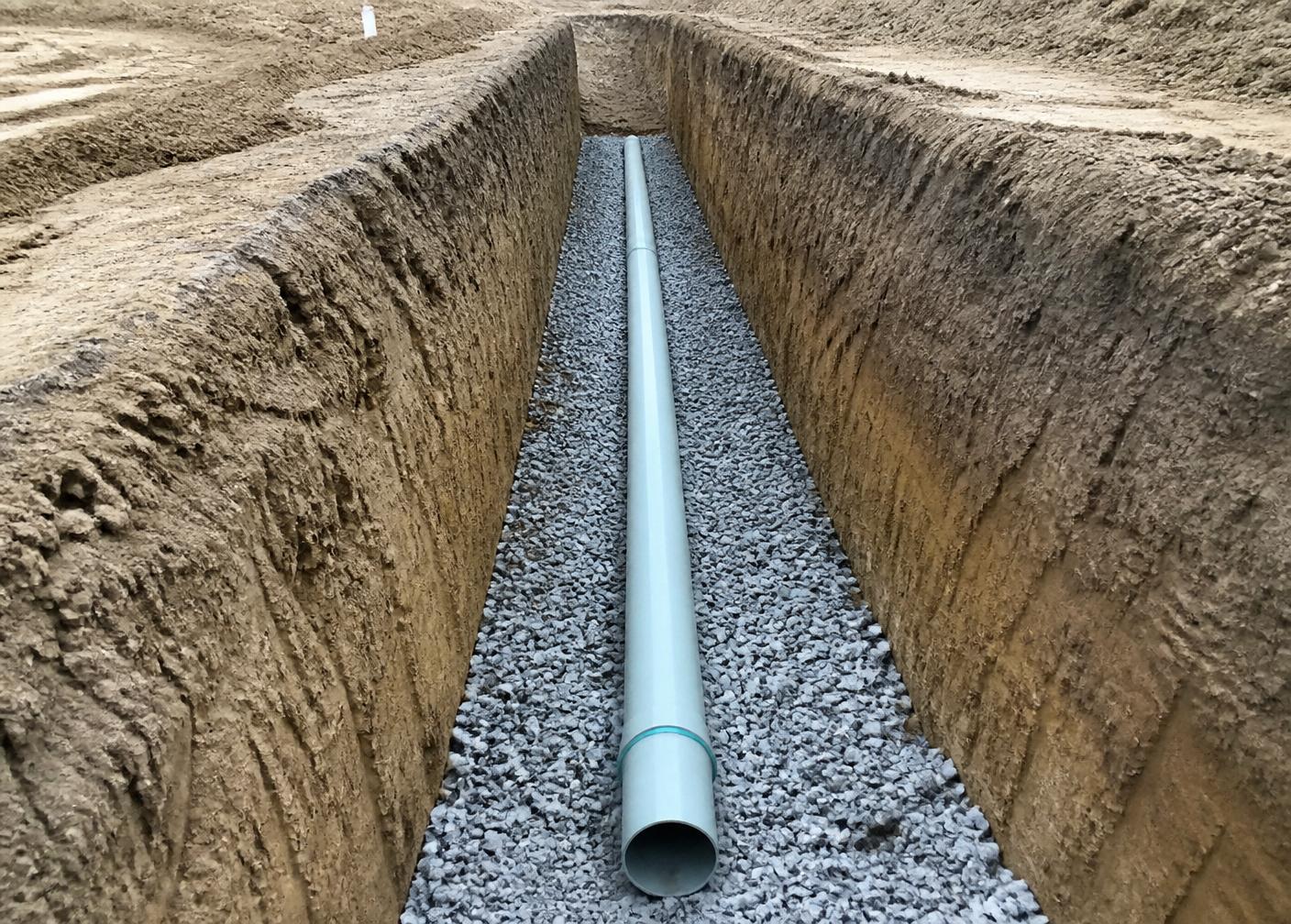 Utility trench with pipe bedded in stone and clean trench walls